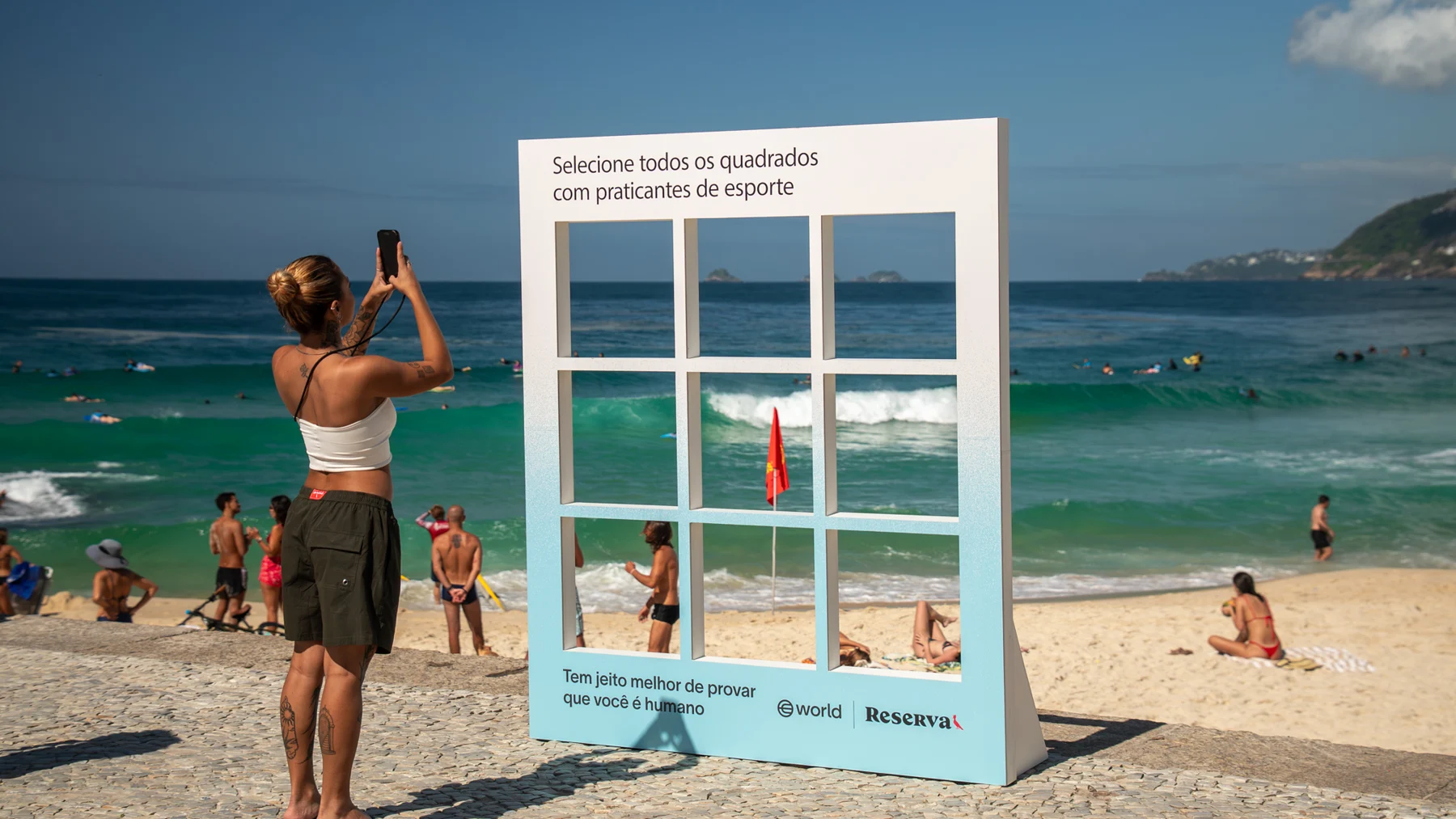Participante fotografa a instalação da World diante do mar