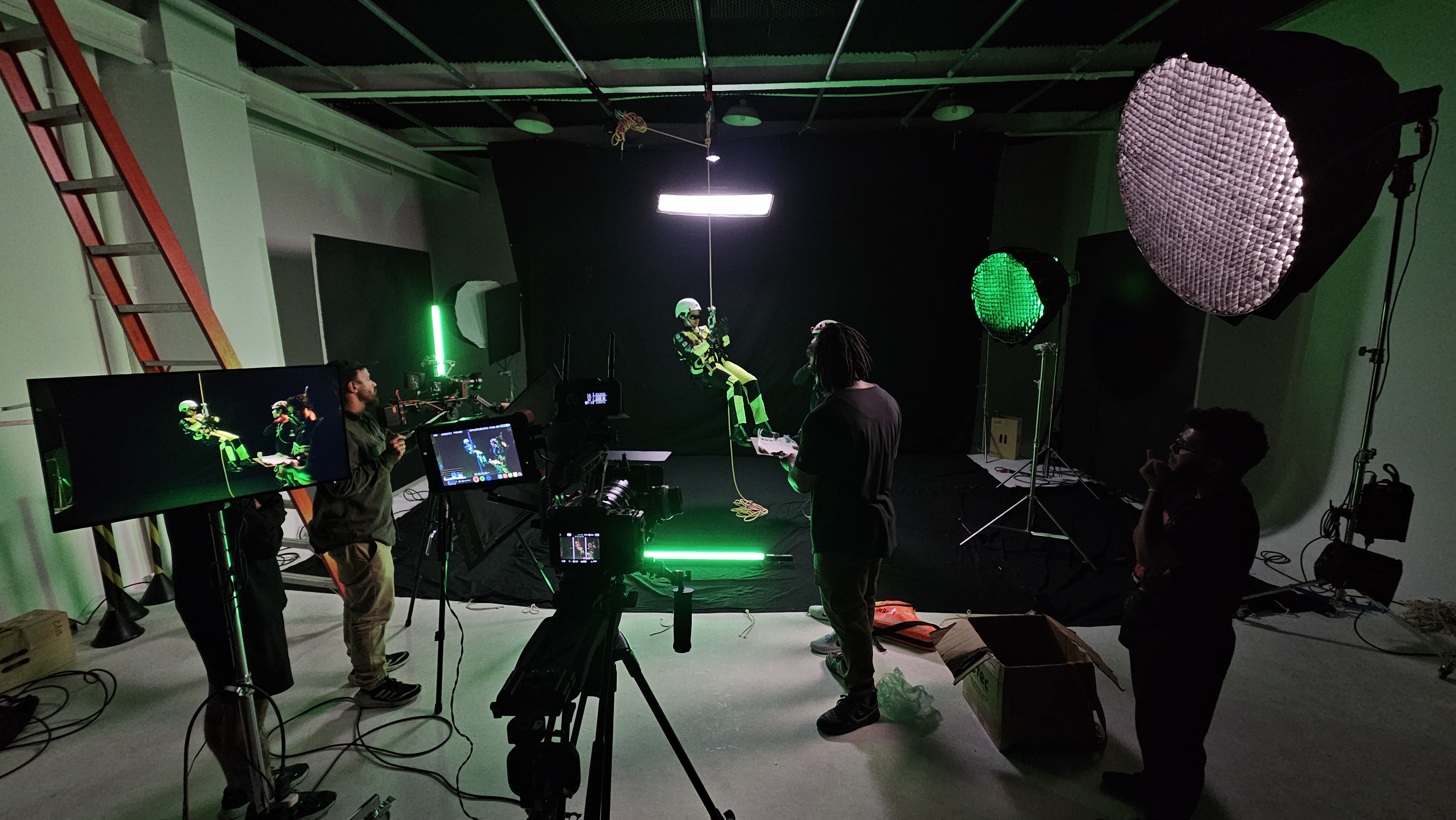 Bastidores de uma filmagem em estúdio, com equipe, câmeras e iluminação